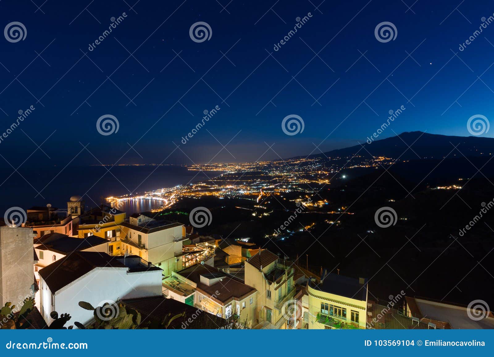 taormina bay and the etna volcano at dusk seen from castelmola