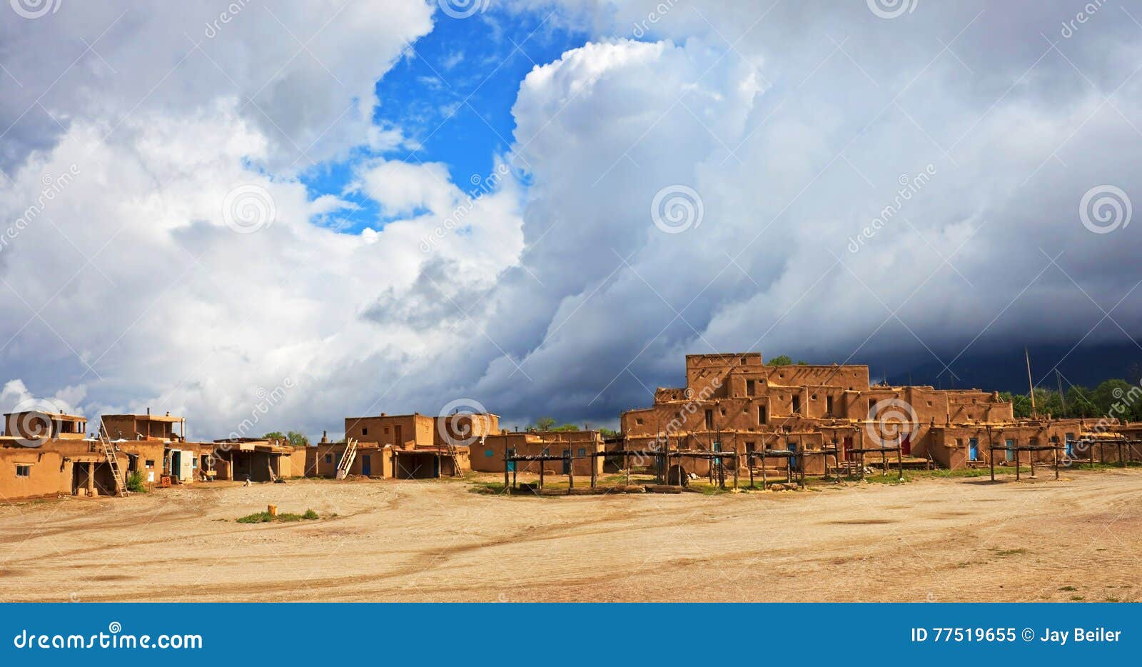 taos pueblo with dramatic clouds, new mexico