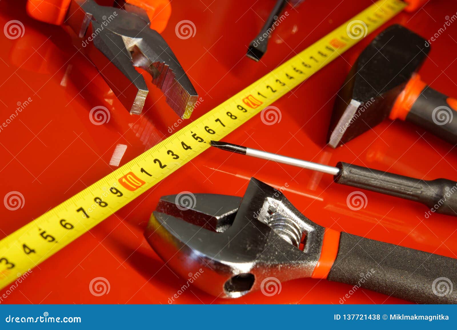 Tape Measure Screwdriver Hammer Pliers And Other Tools Lie On A Red