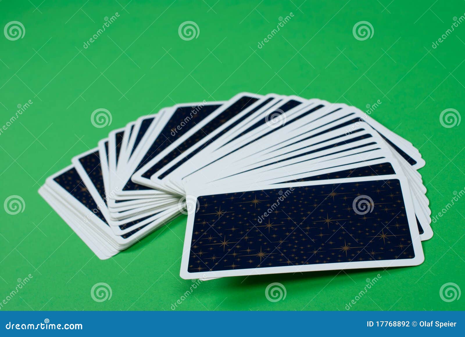 Deck of tarot cards fanned out on a green table