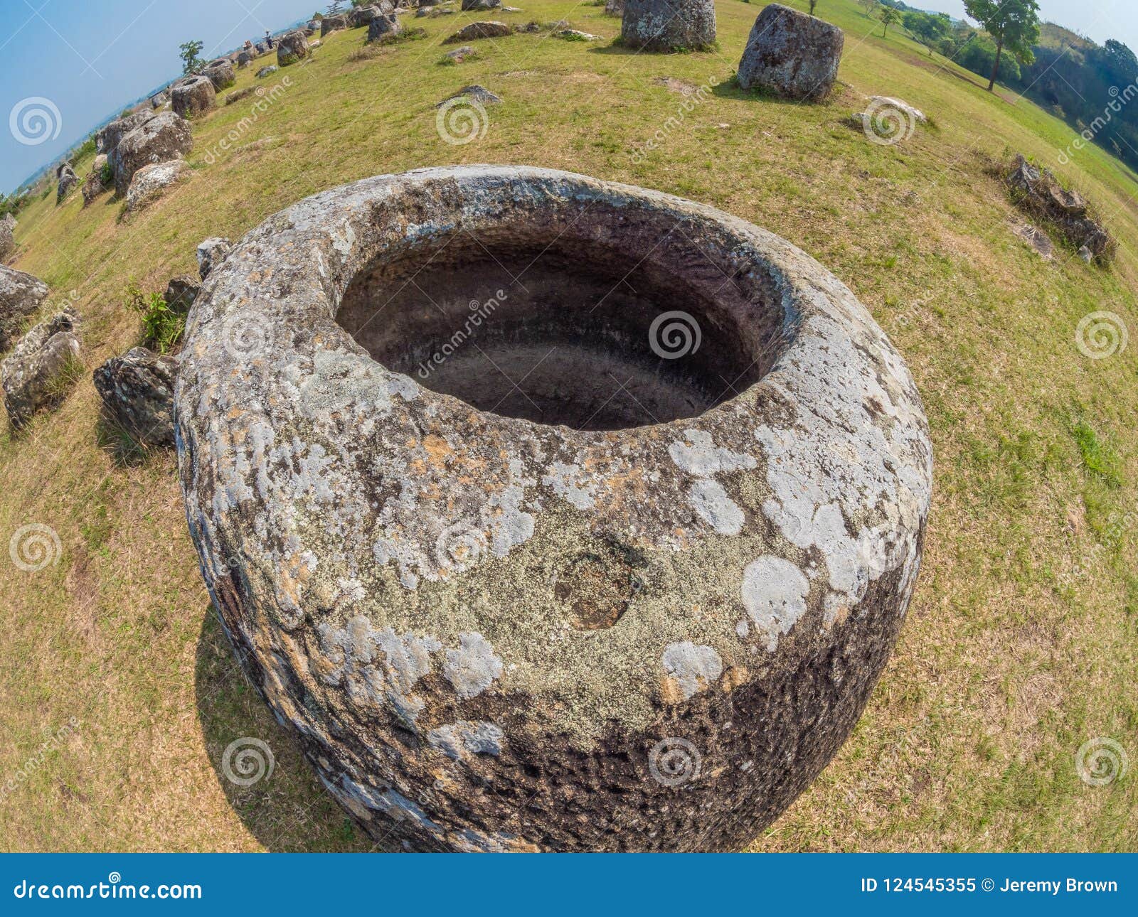 Tarros gigantes de la piedra de la edad de hierro Meseta de Xiangkhoang, Laos. Tarros de piedra gigantes antiguos, 500 A.C. al ANUNCIO 500 Llano paisaje arqueológico megalítico del àº'àº™ del àº “àº del „“del à del” del ‡ del ˆàº del” à” del àº-àº de los tarros, meseta de Xiangkhoang, Laos Sitio de la UNESCO en Asia sudoriental Tarros de piedra grandes de piedra arenisca, de granito, de conglomerado, de piedra caliza, o de brecha Las grandes cantidades de bombas americanas inexplotadas de la guerra de Vietnam en esta área de Laos, localizan solamente despejado y marcado por el grupo consultivo mA de las minas