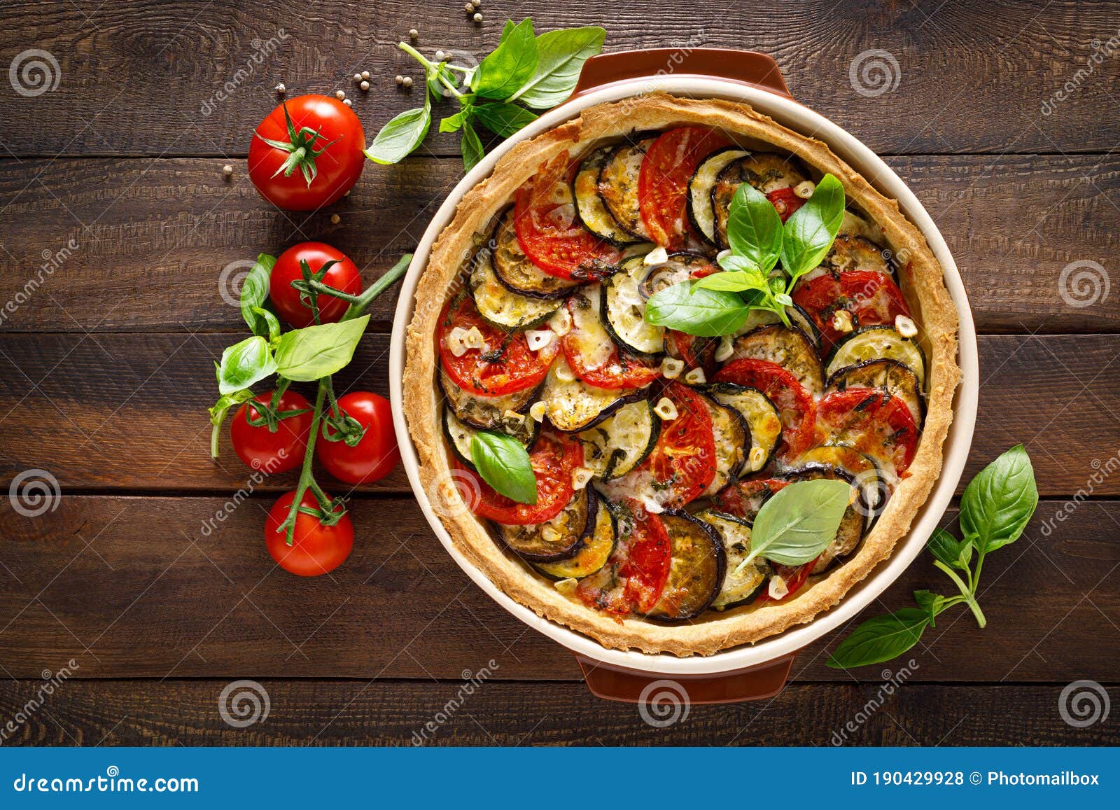 tart with vegetables. homemade savory tart with eggplant, zucchini, tomatoes, garlic, mozzarella cheese and fresh basil. mediterra