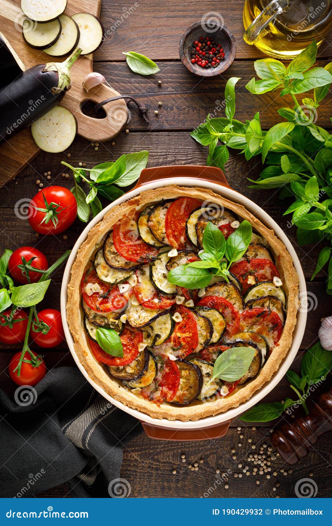 tart with vegetables. homemade savory tart with eggplant, zucchini, tomatoes, garlic, mozzarella cheese and fresh basil. mediterra