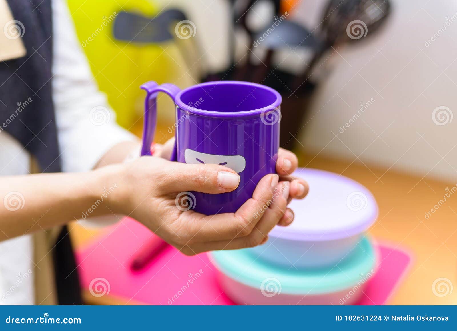 Tasse En Plastique De Prise De Mains Avec Le Visage De Sourire