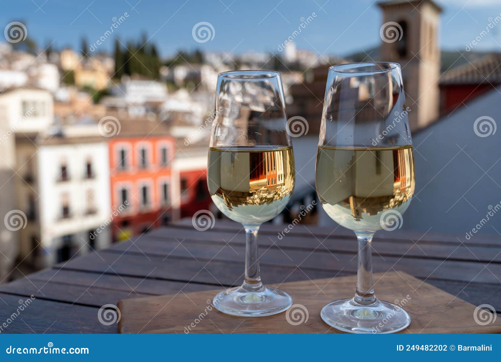 tasting of sweet and dry fortified vino de jerez sherry wine with view on roofs and houses of old andalusian town