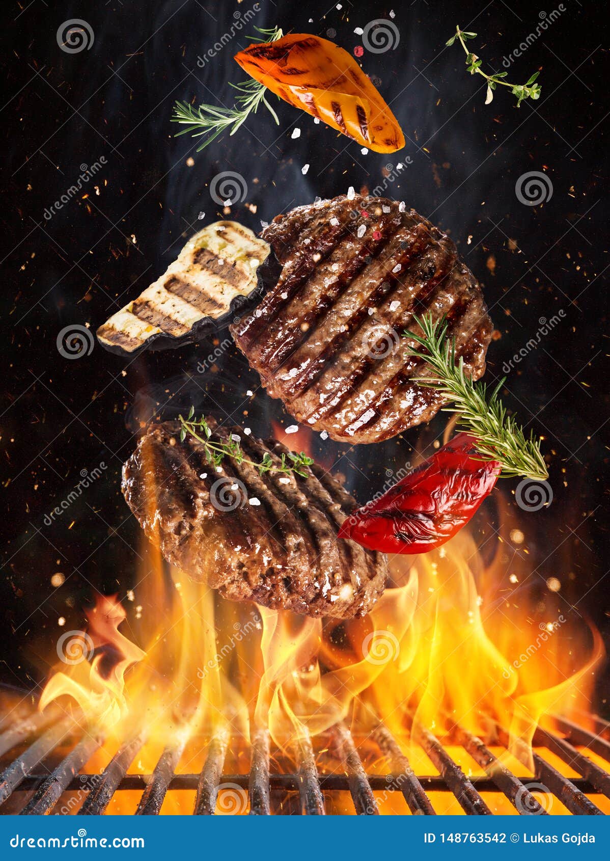 Tasty Beef Steaks Flying Above Cast Iron Grate with Fire Flames. Stock ...