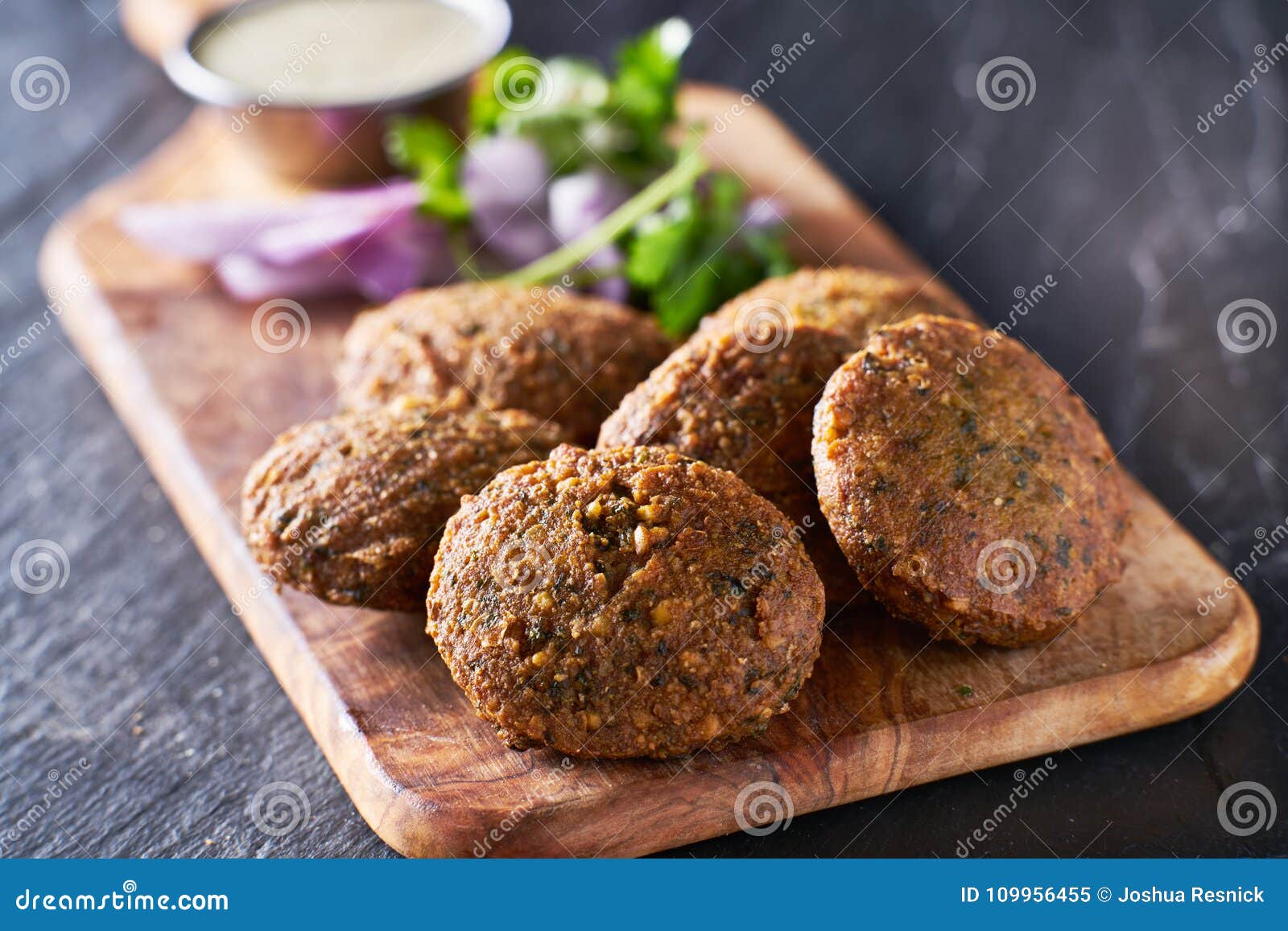 tasty falafel pieces on wooden bread board