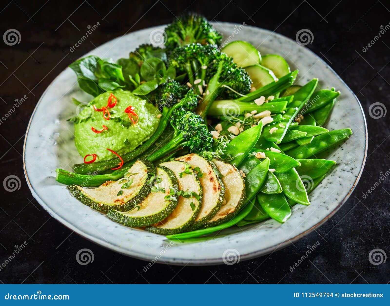tasty green vegetable buddha bowl with avocado dip