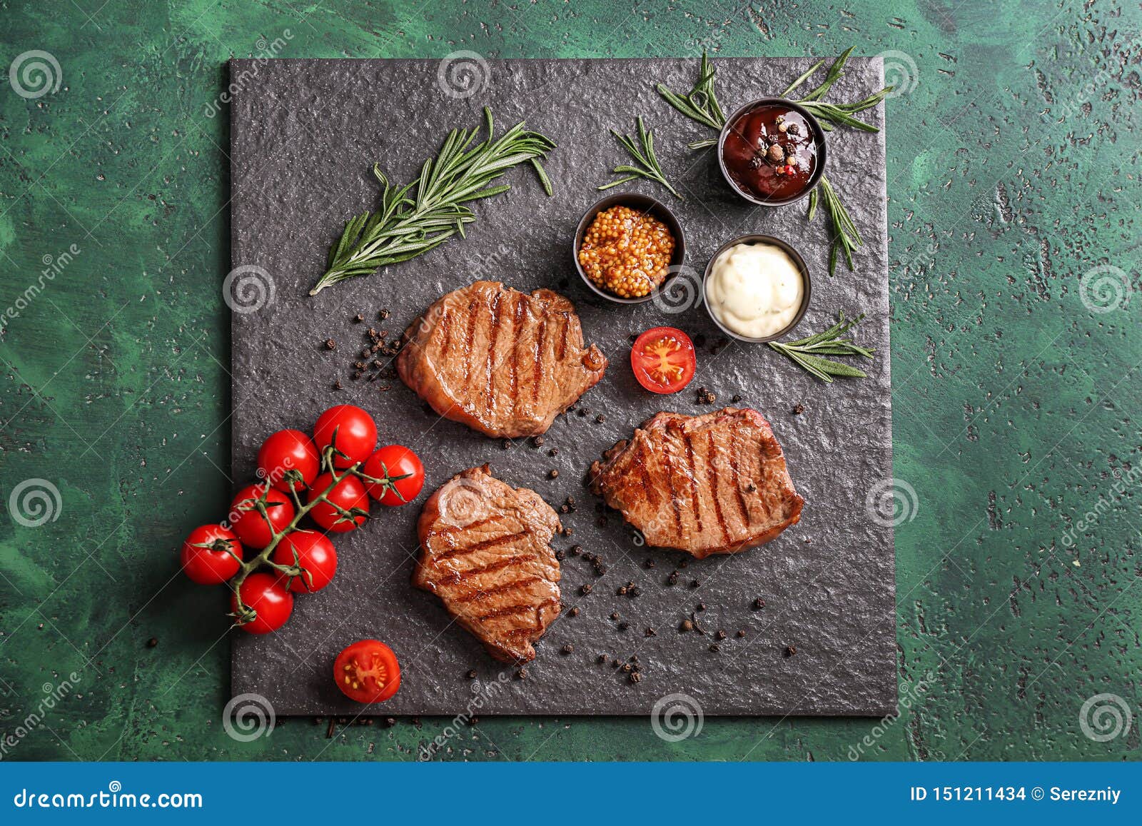 Tasty Grilled Steaks with Different Sauces on Slate Plate Stock Photo