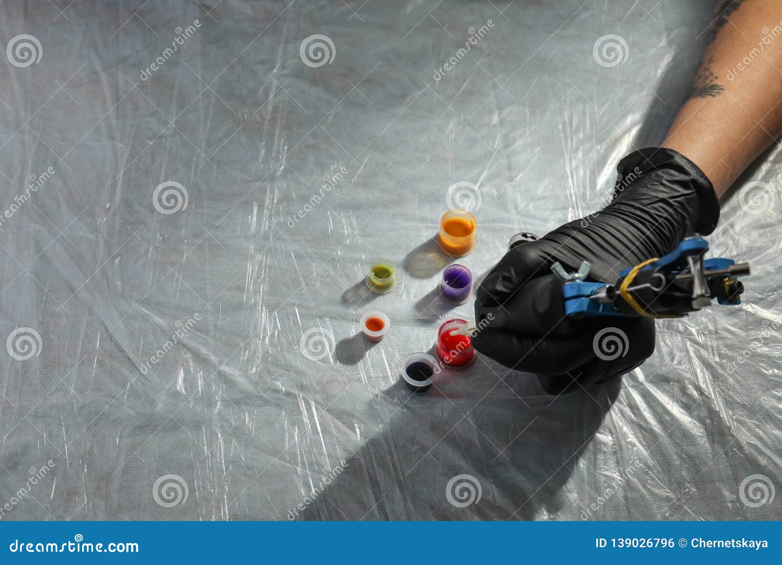 Tattoo Artist with Machine and Inks at Table. Space for Text Stock