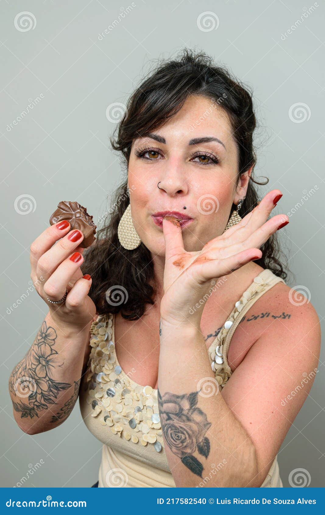 Tattooed Woman Licking Or Finger Securing A Bolo Of Brazilian Mel And