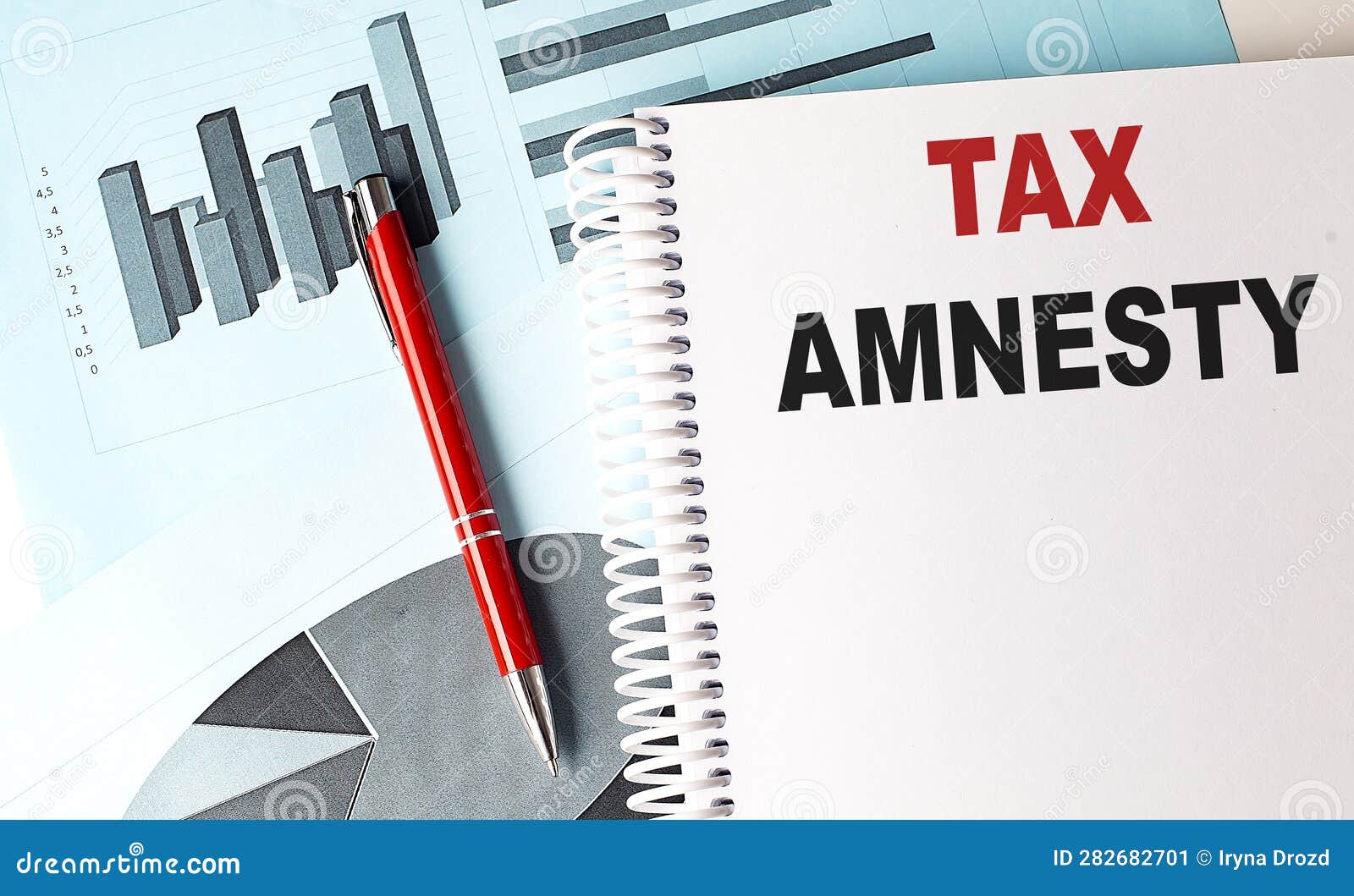tax amnesty text on a notebook with pen on a chart background