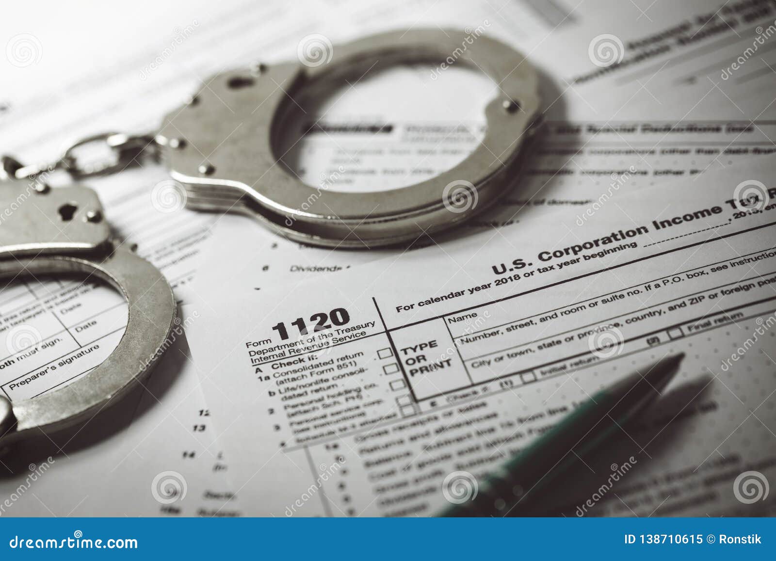 tax evasion concept - tax form 1120 and handcuffs