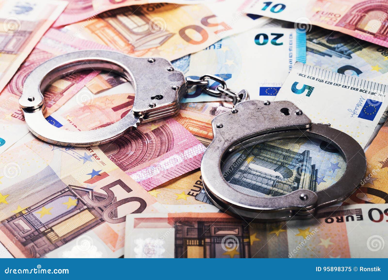 tax evasion, corruption concept - handcuffs on euro money bills