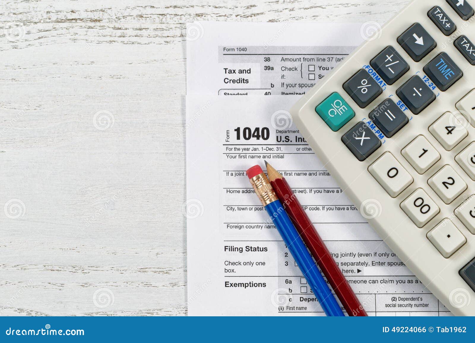 Tax forms on Desktop. Top view of U.S. Individual tax form 1040 with old calculator and pencils on wooden desktop