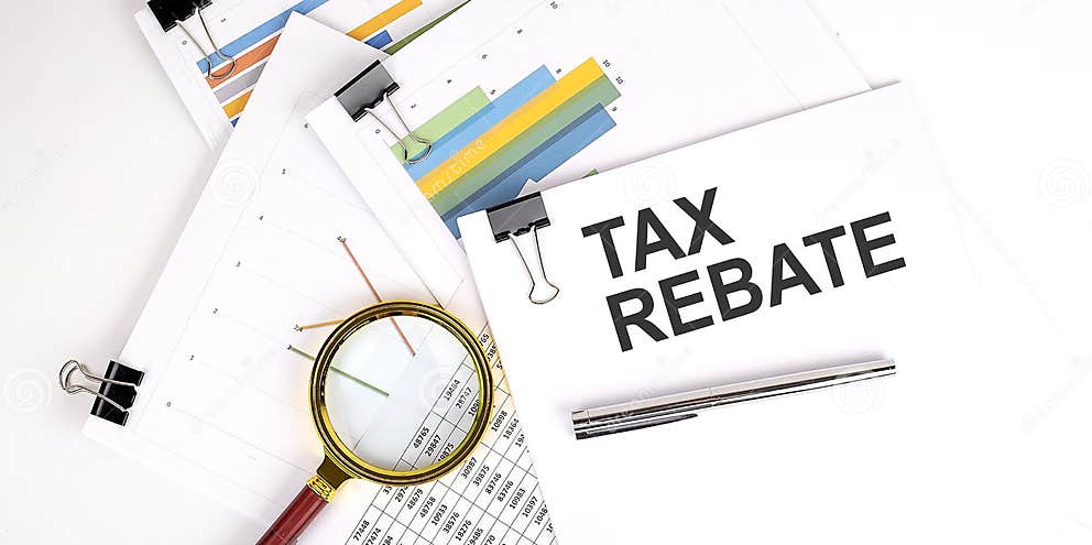 TAX REBATE Text On White Paper On The Light Background With Charts 