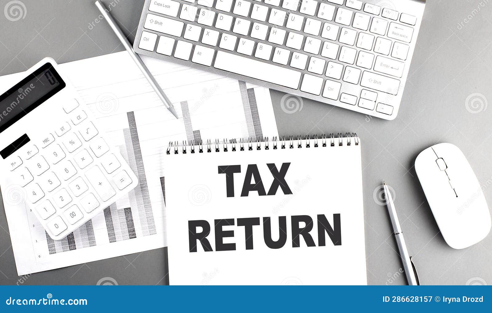 tax return text written on notebook on grey background with chart and keyboard , business concept