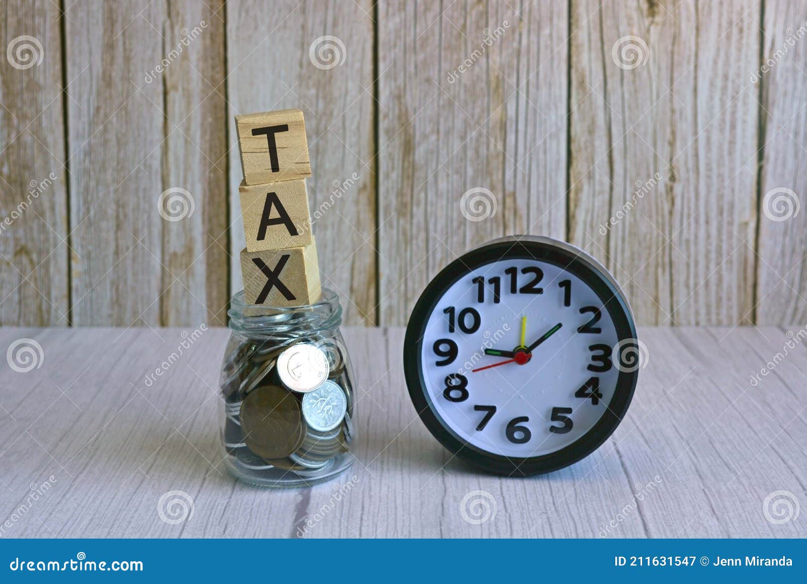tax text on wooden block cube on top of glass jar with multicurrency coins