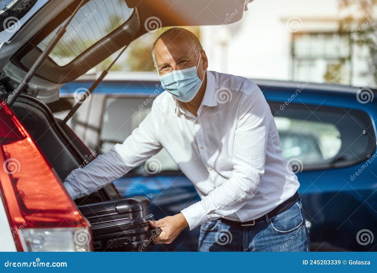 A Taxi or Uber Driver Unloading the Luggage from the Trunk of the Car