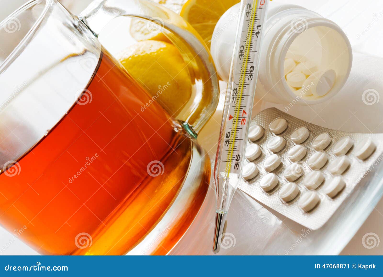 tea with lemons and flu pills with thermometer - grippe remedy