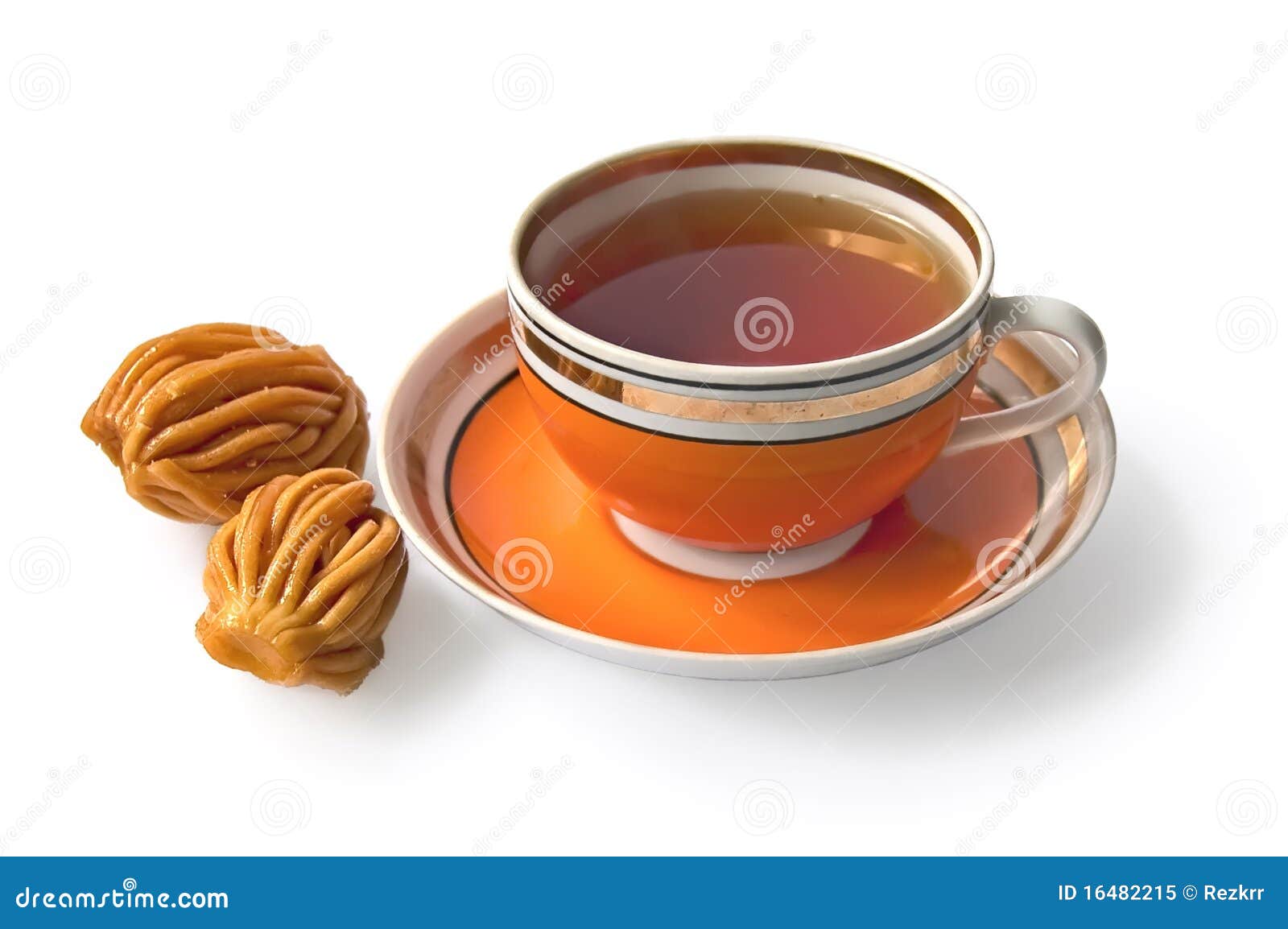 Tea in an orange cup with nath. Tea in the orange bowl with oriental sweets with a light shade on white background