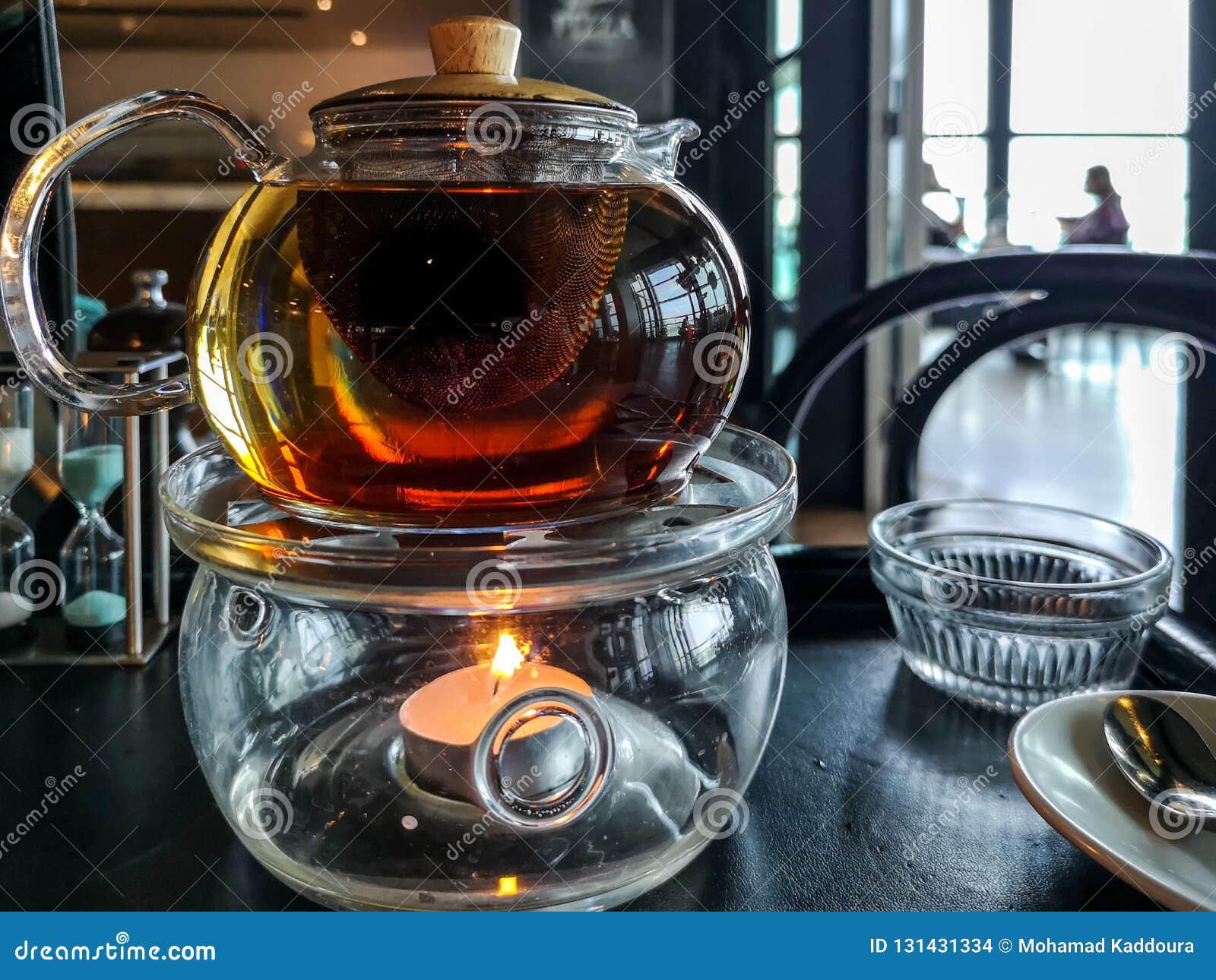Tea Pot Above a Candle with Restaurant Background Stock Photo Image