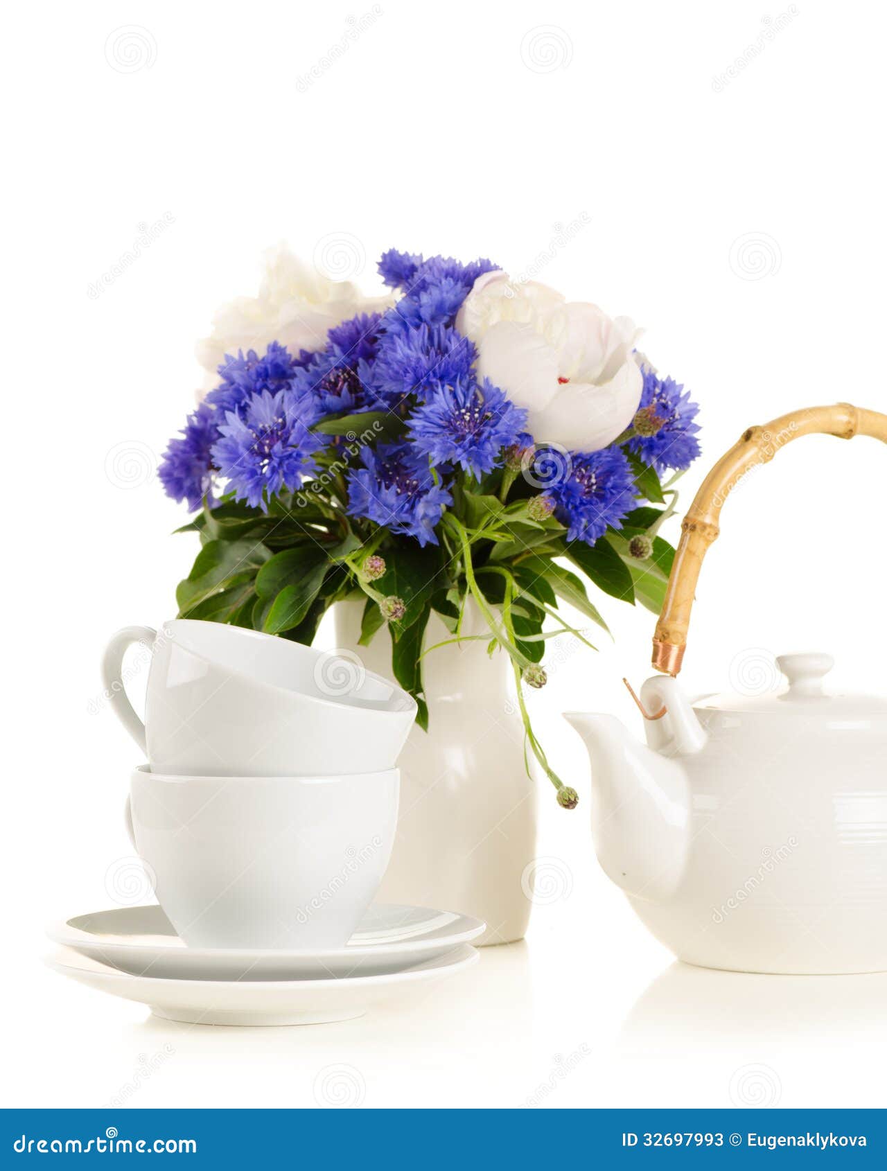 Tea Pot and Cups on Table with Blue and White Bouquet on White B Stock