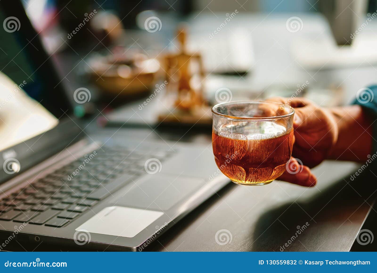 Tea Time Concept .hand Holding Tea Cup on Office Table with Lap Stock