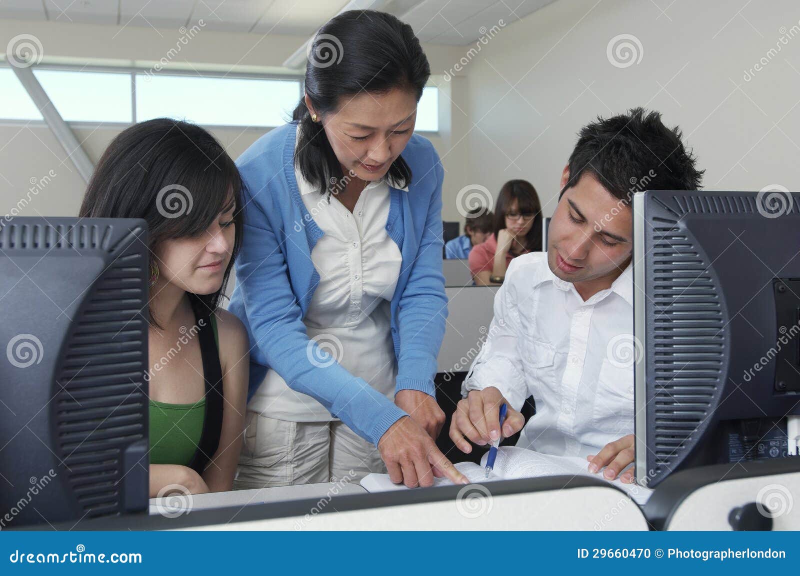 teacher assisting students in computer lab