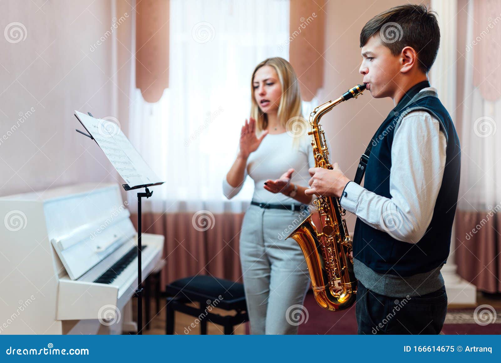 teacher claps instead of a metronome for a student on saxophone in music lesson that focuses on playing