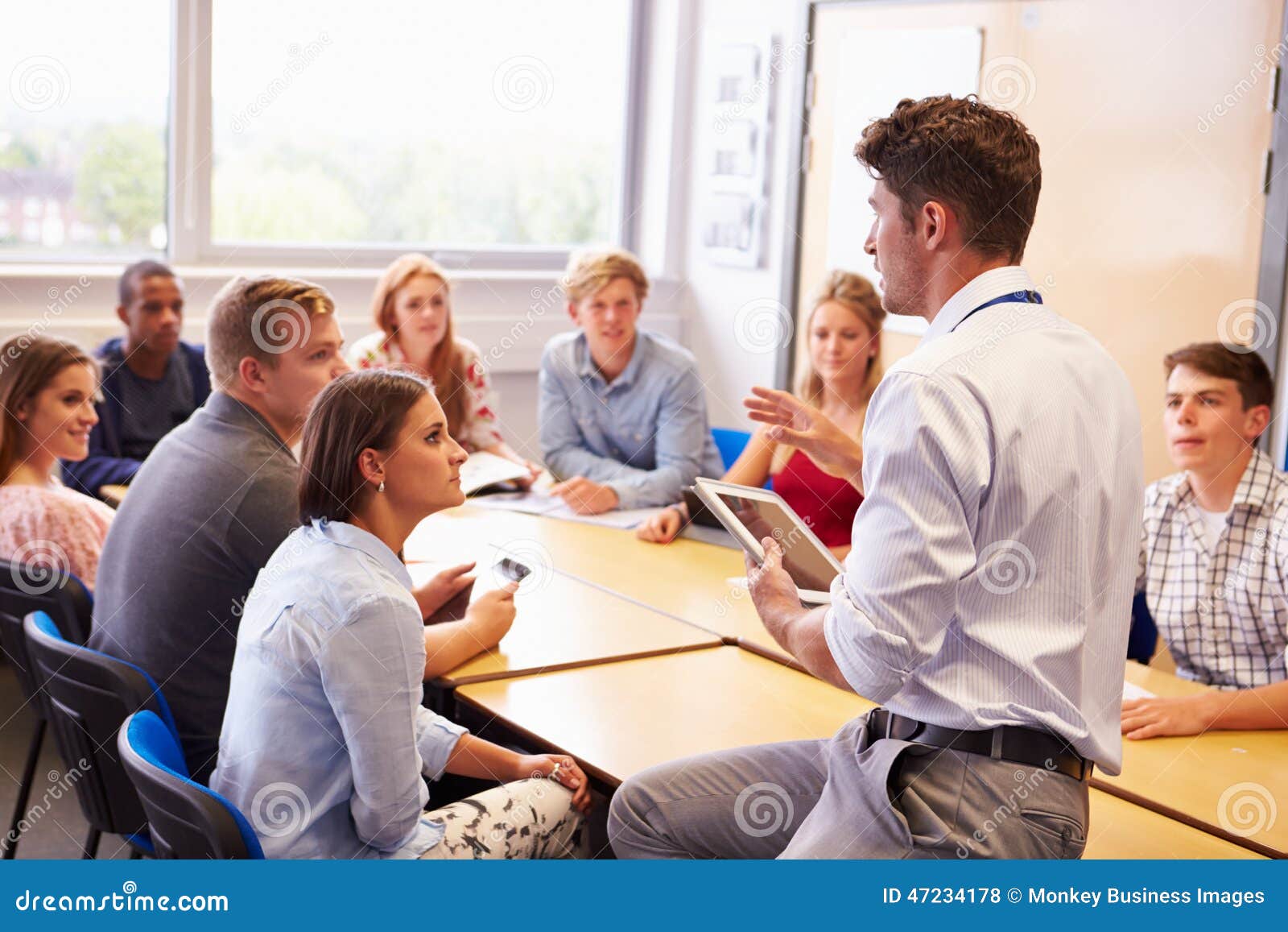 teacher with college students giving lesson in classroom