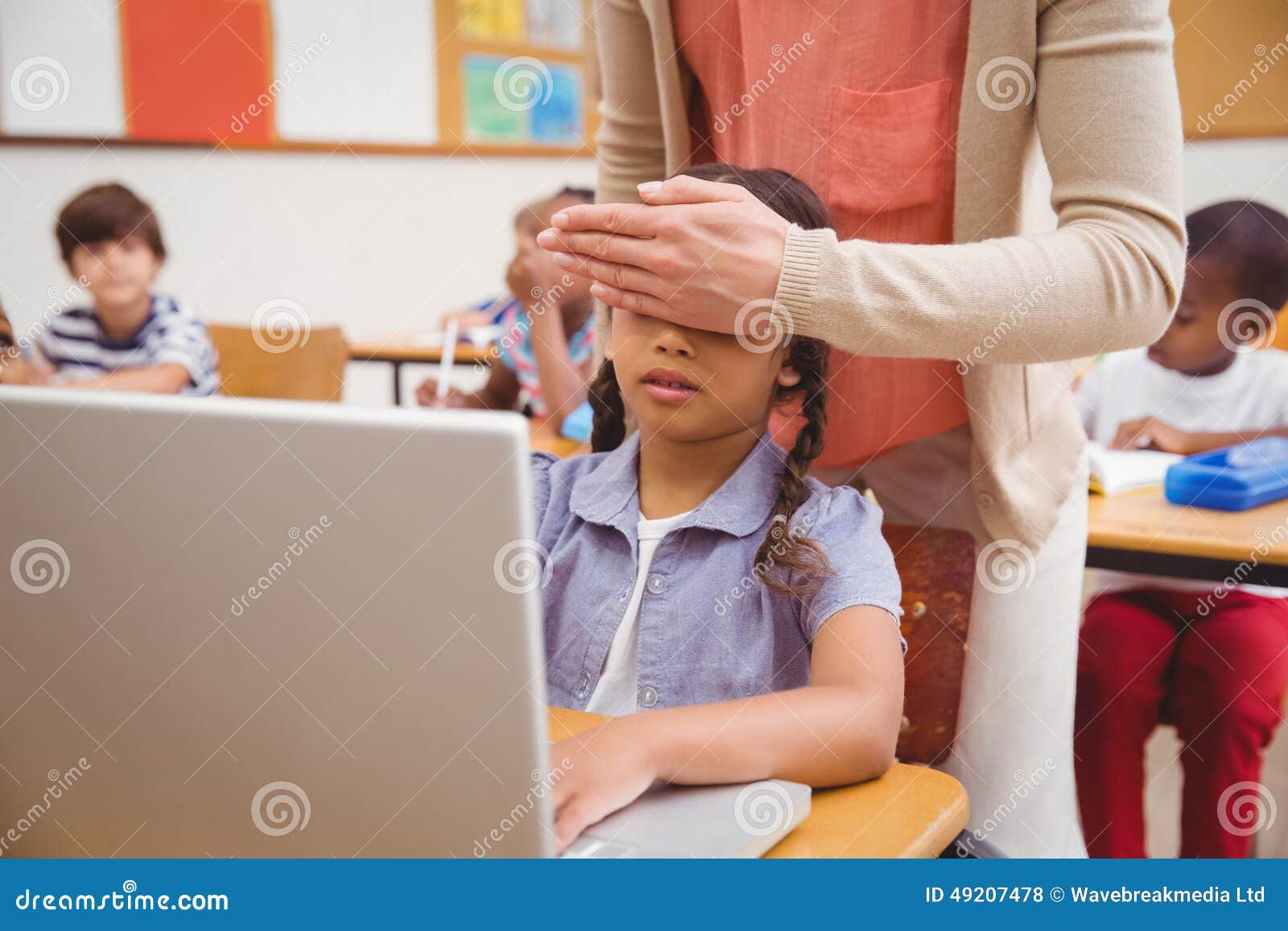 Teacher Covering Pupil Eyes in Front of the Computer Stock Photo