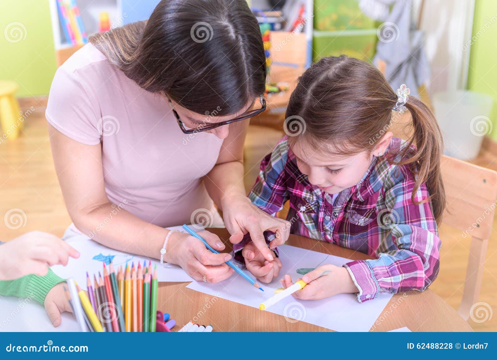teacher harnessing kids creativity in the kindergarten and preschool