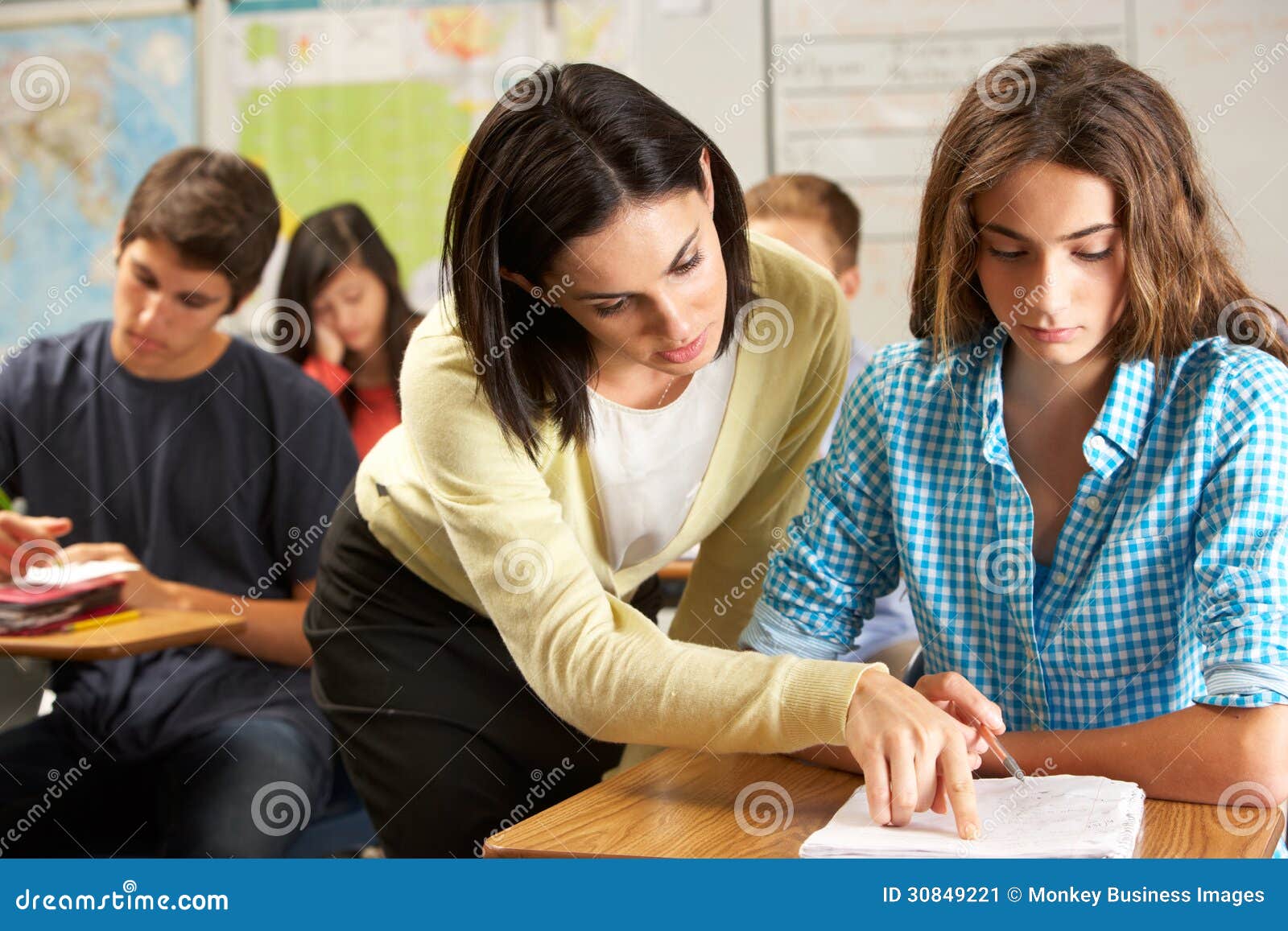 Teacher Helping Female Pupil Studying at Desk in Classroom Stock Image Image of foreground