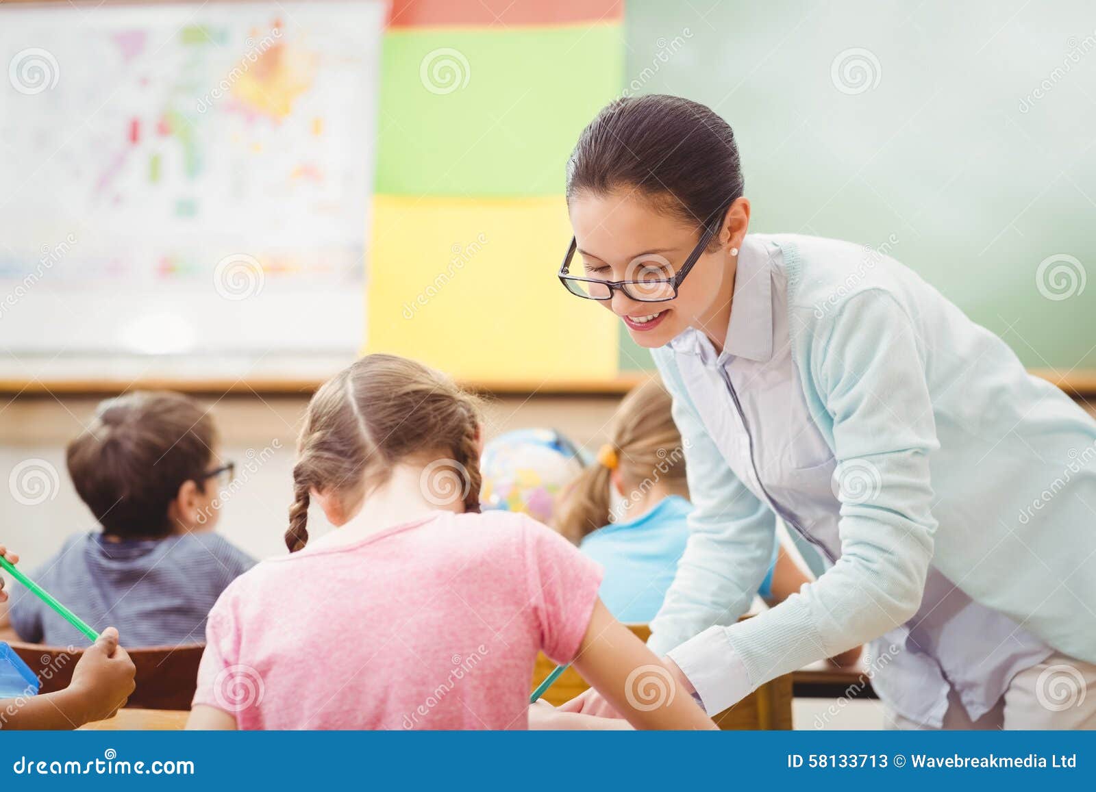 Teacher Helping A Pupil During Class Stock Image Image Of Desk