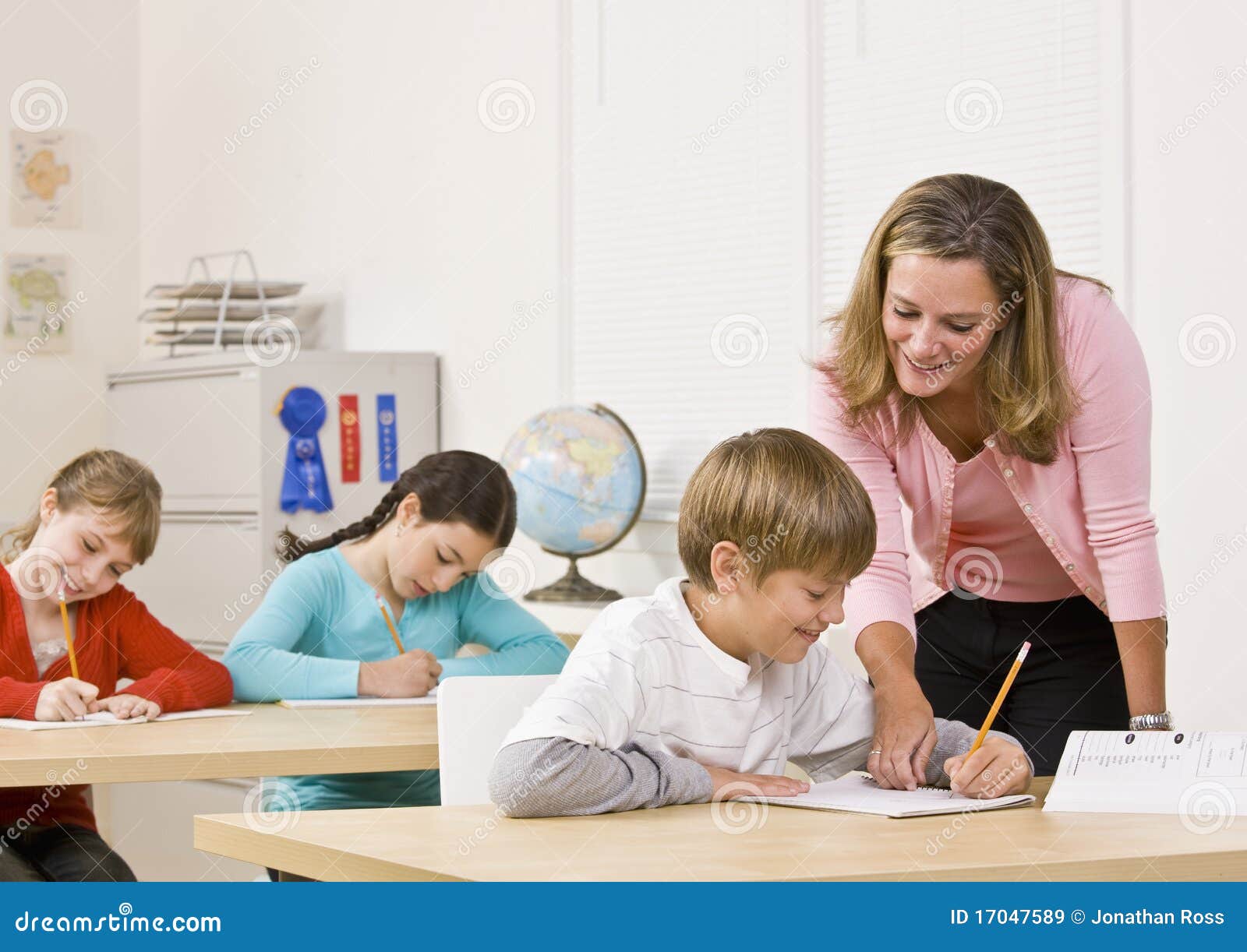 teacher helping student in classroom