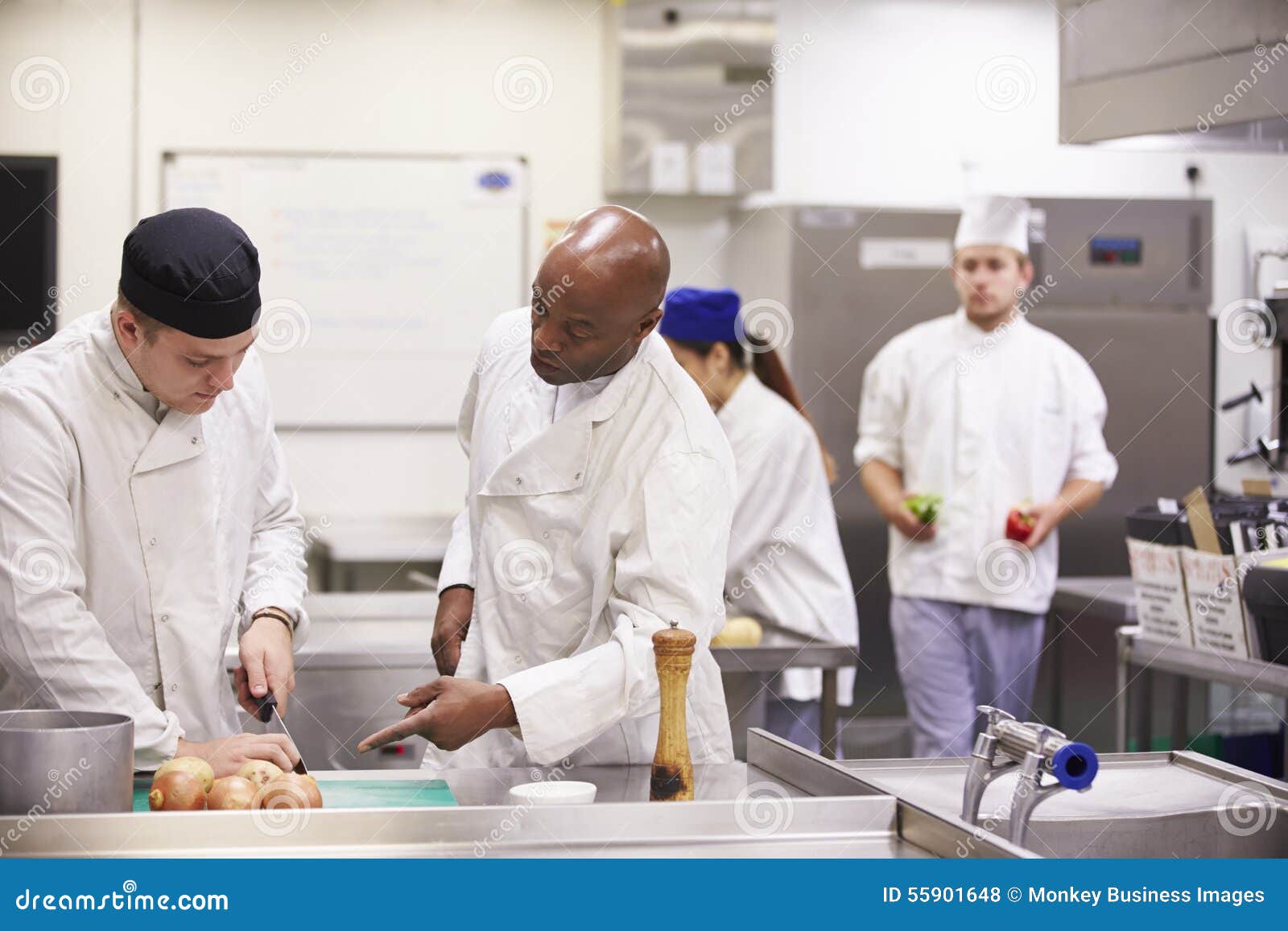 Teacher Helping Students Training To Work in Catering Stock Photo
