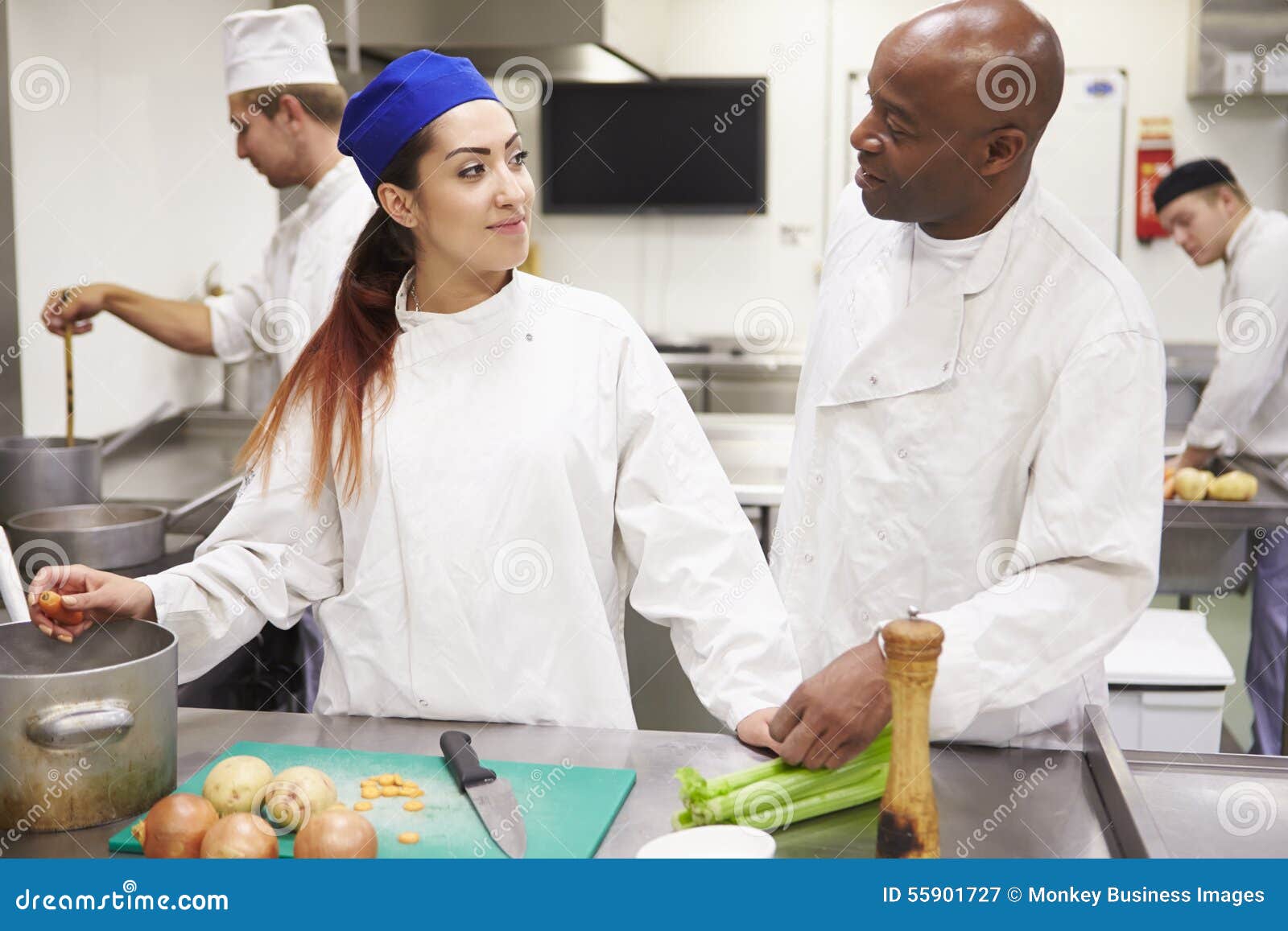 Teacher Helping Students Training To Work in Catering Stock Image