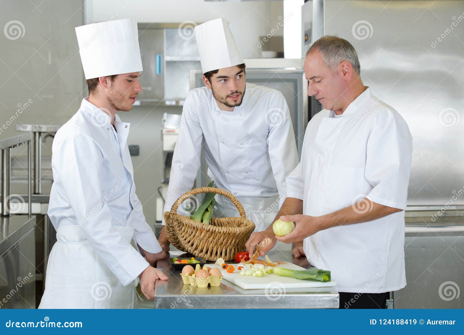 Teacher Helping Students Training To Work in Catering Stock Image