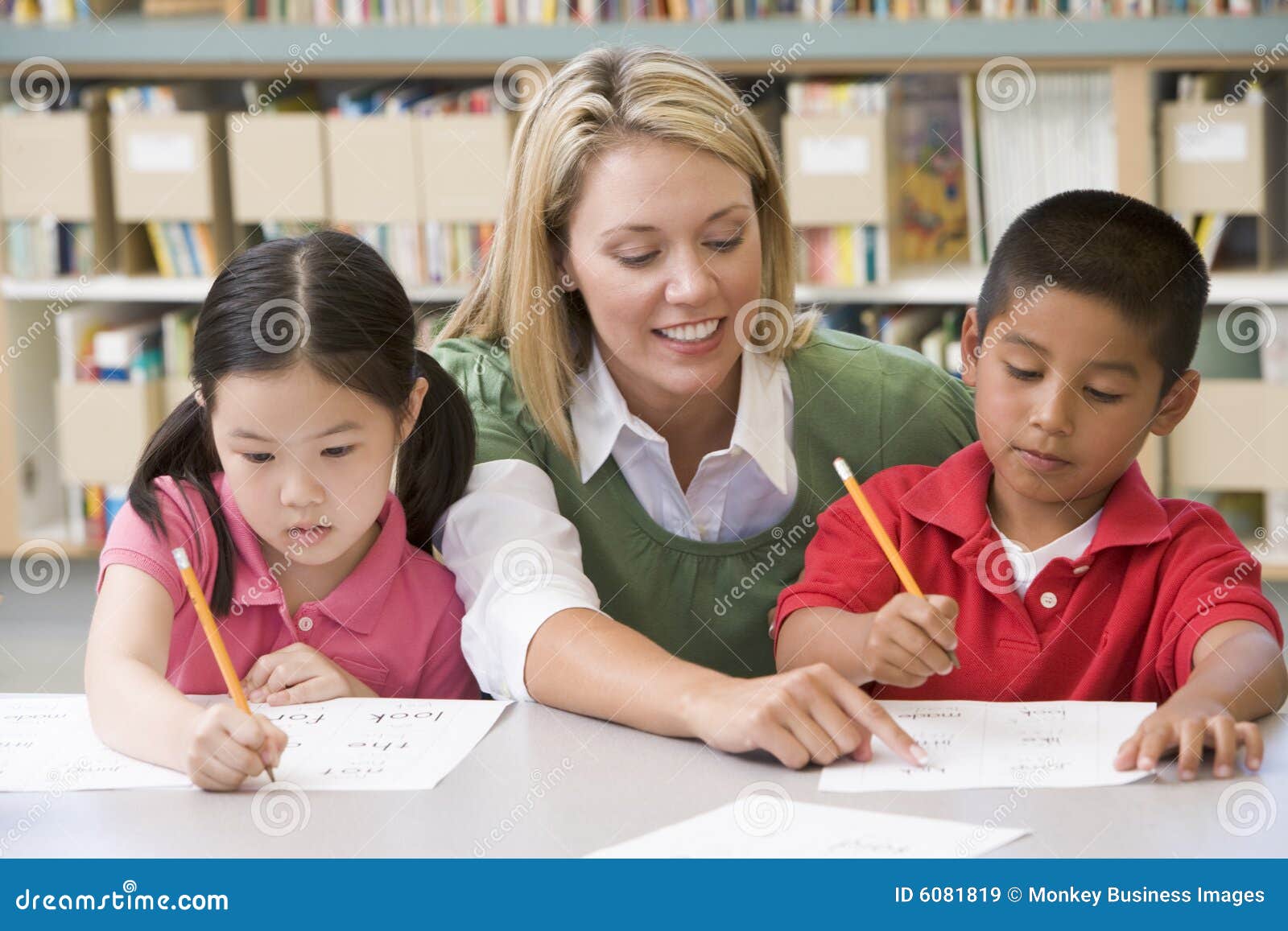 Teacher Helping Students With Writing Skills Stock Image