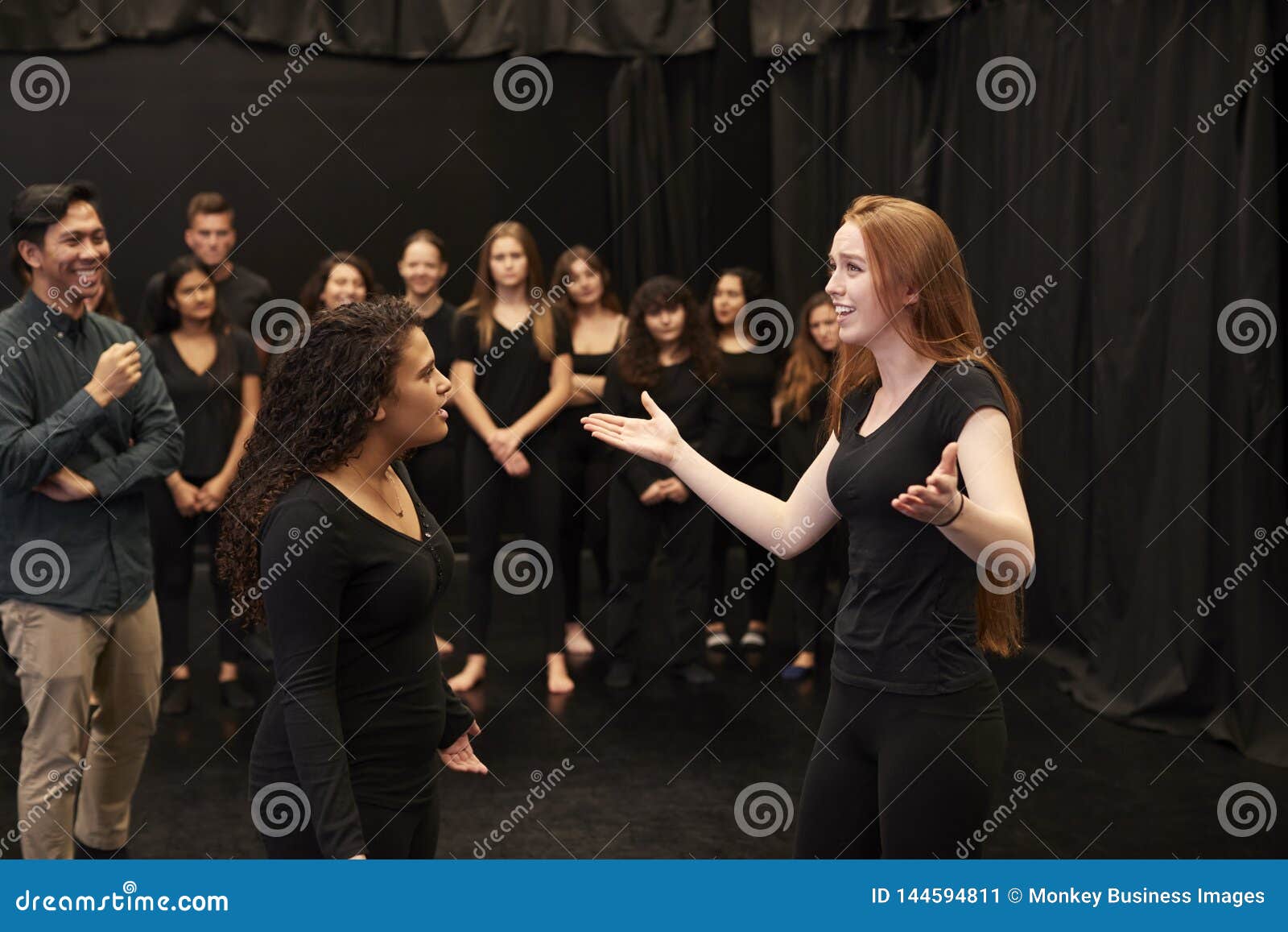 teacher with male and female drama students at performing arts school in studio improvisation class