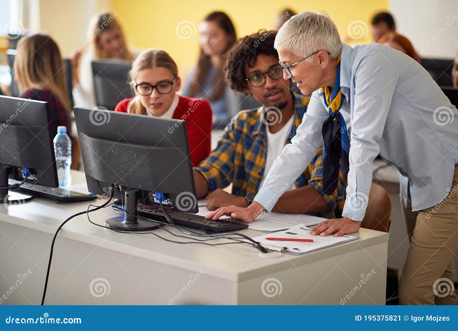 teacher with pupil looking at computer