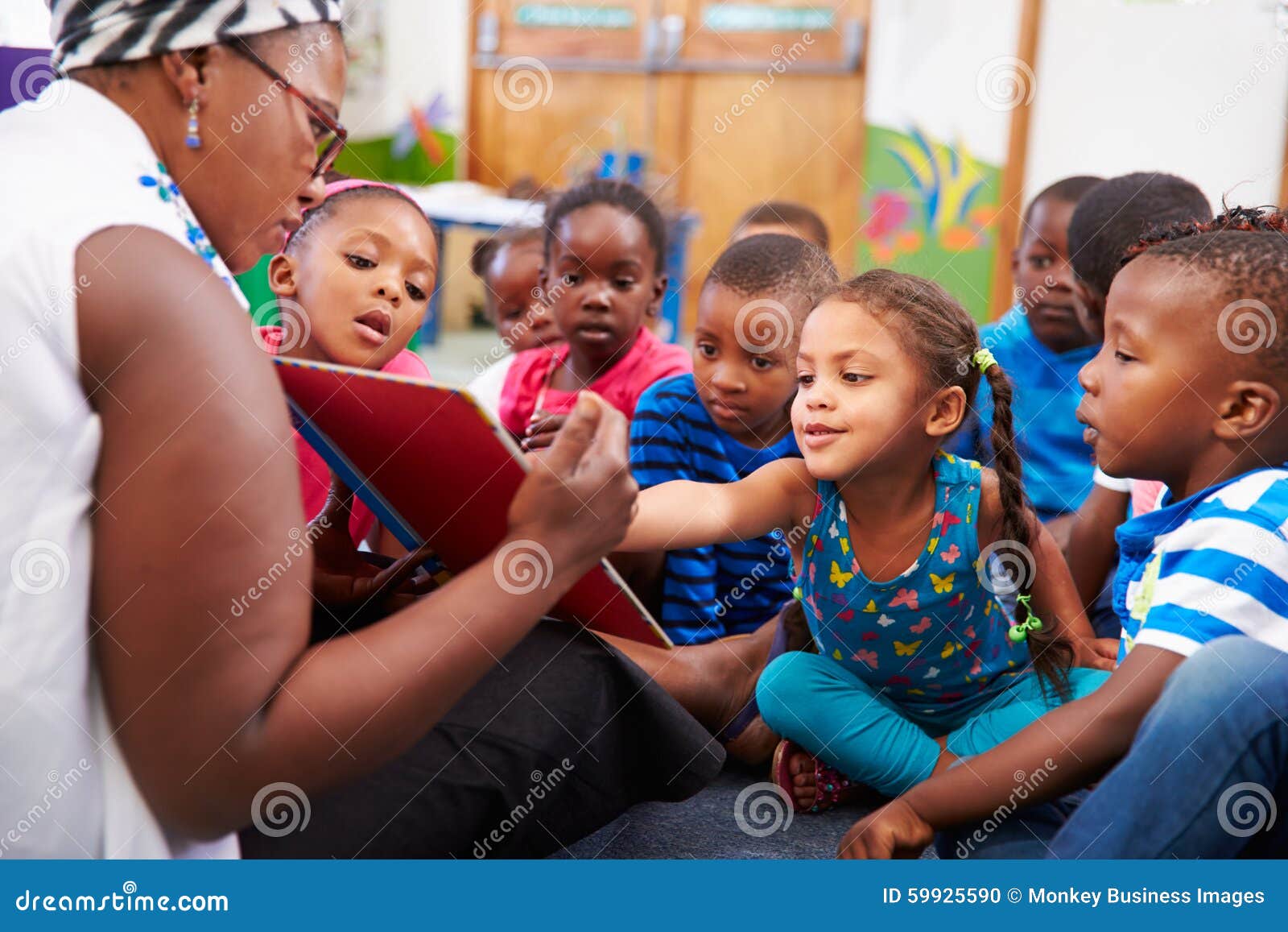 teacher reading a book with a class of preschool children