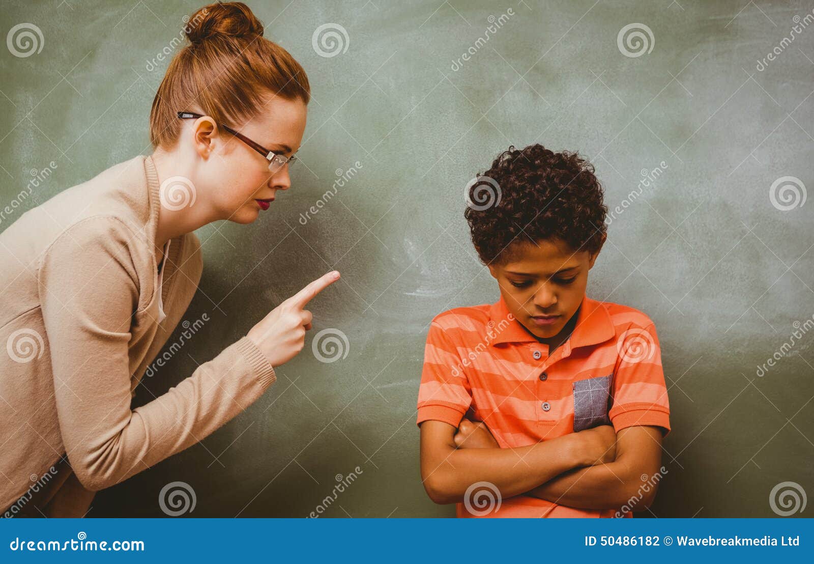 teacher shouting at boy in classroom