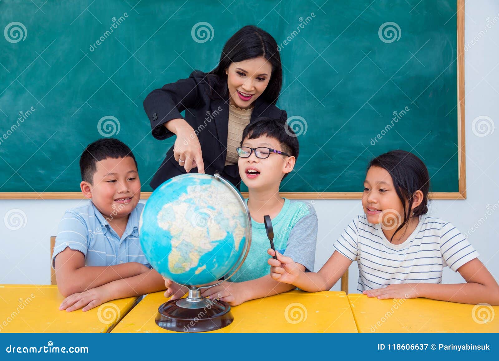 teacher and students studying geography in class