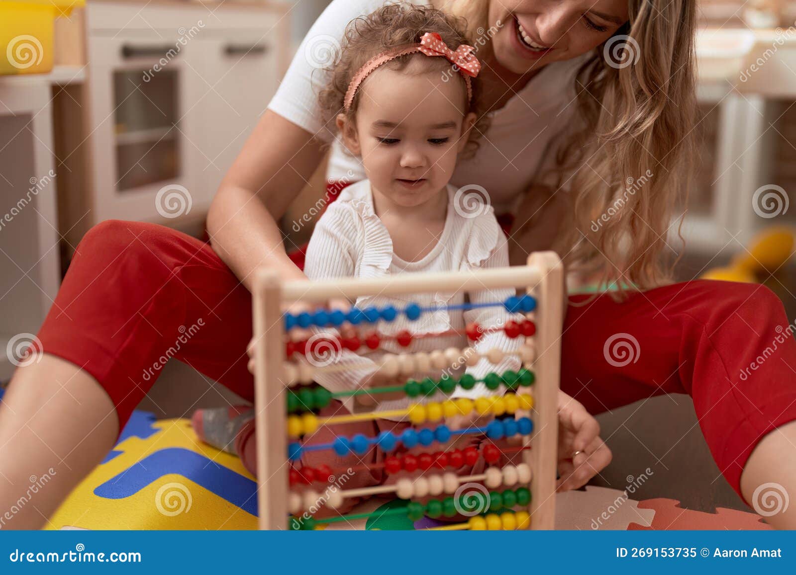 Teacher and Toddler Learning Maths with Abacus Sitting on Floor at