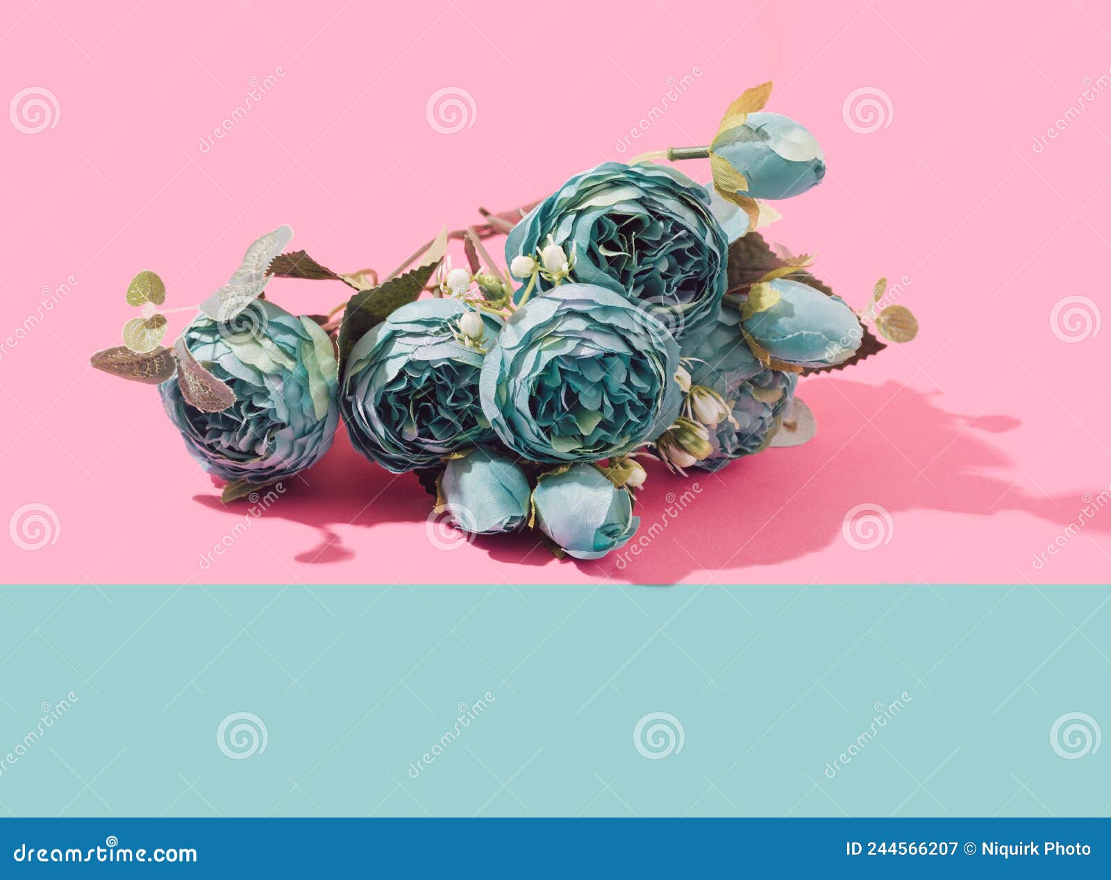 teal peonia artificial flowers bouquet on a two tone pastel background.