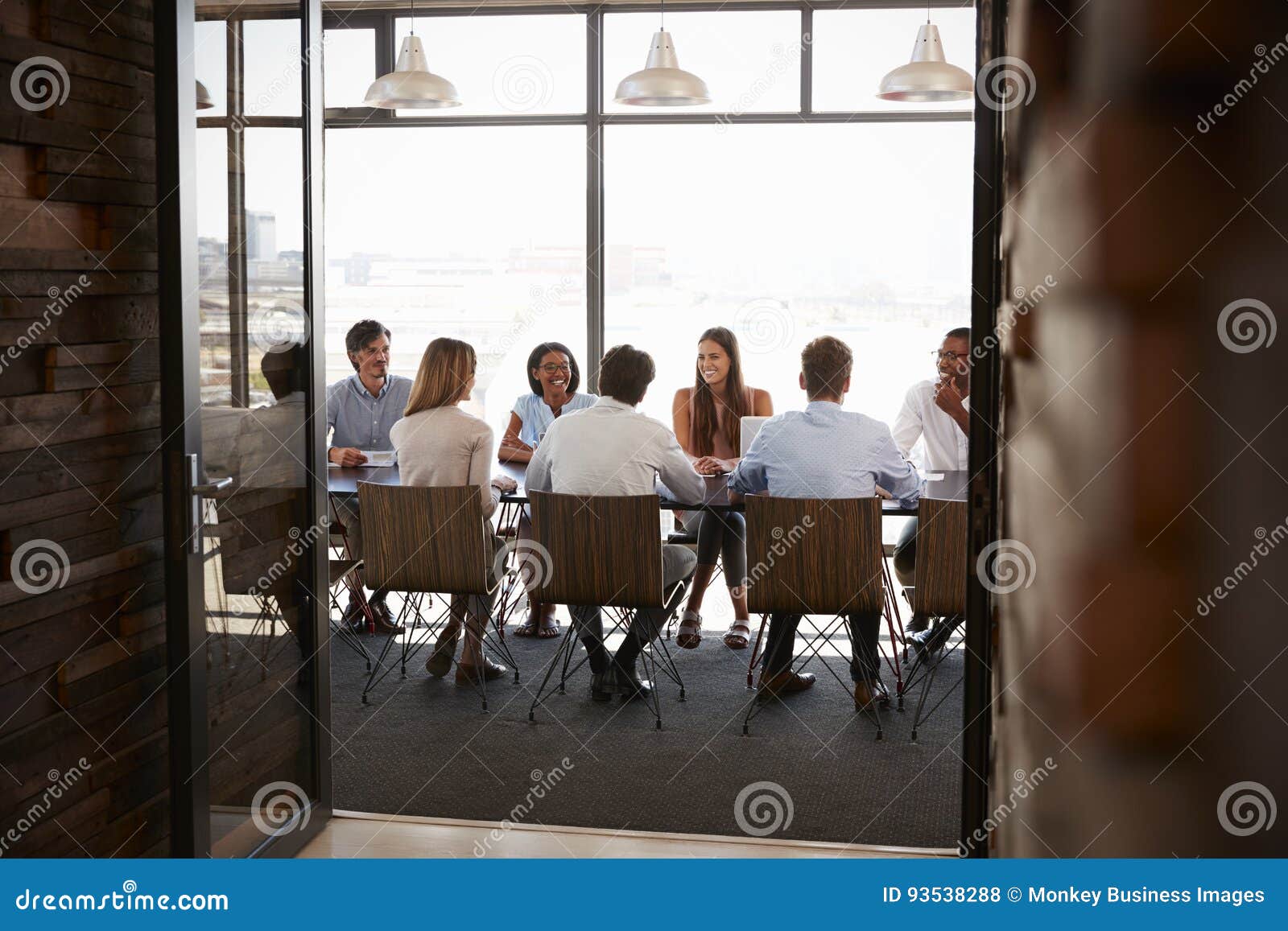Team in a Boardroom Meeting Seen through Open Doors, Full Length Stock