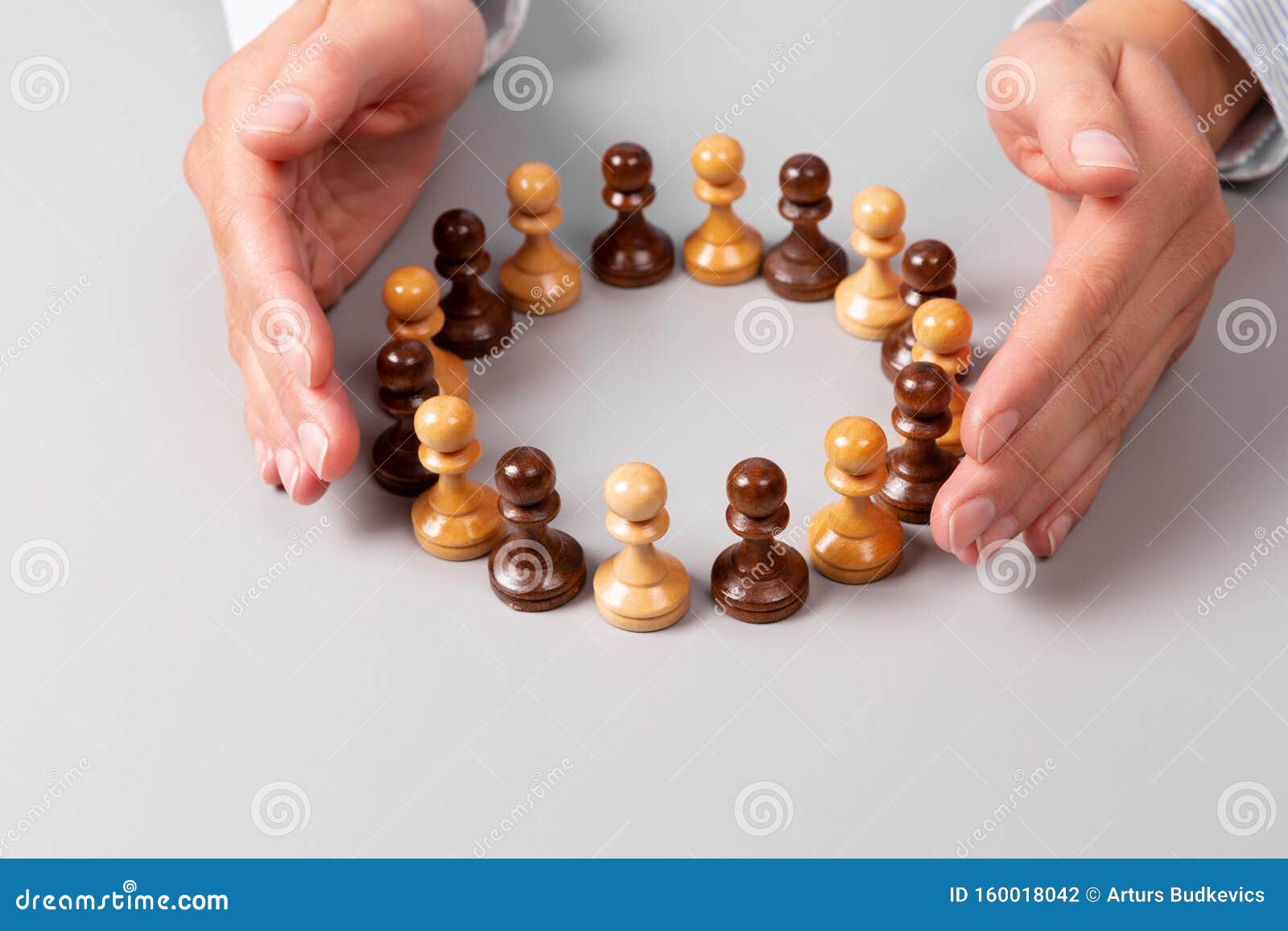team concept, leadership concept. woman`s hands surrounding chess pawns standing in circle