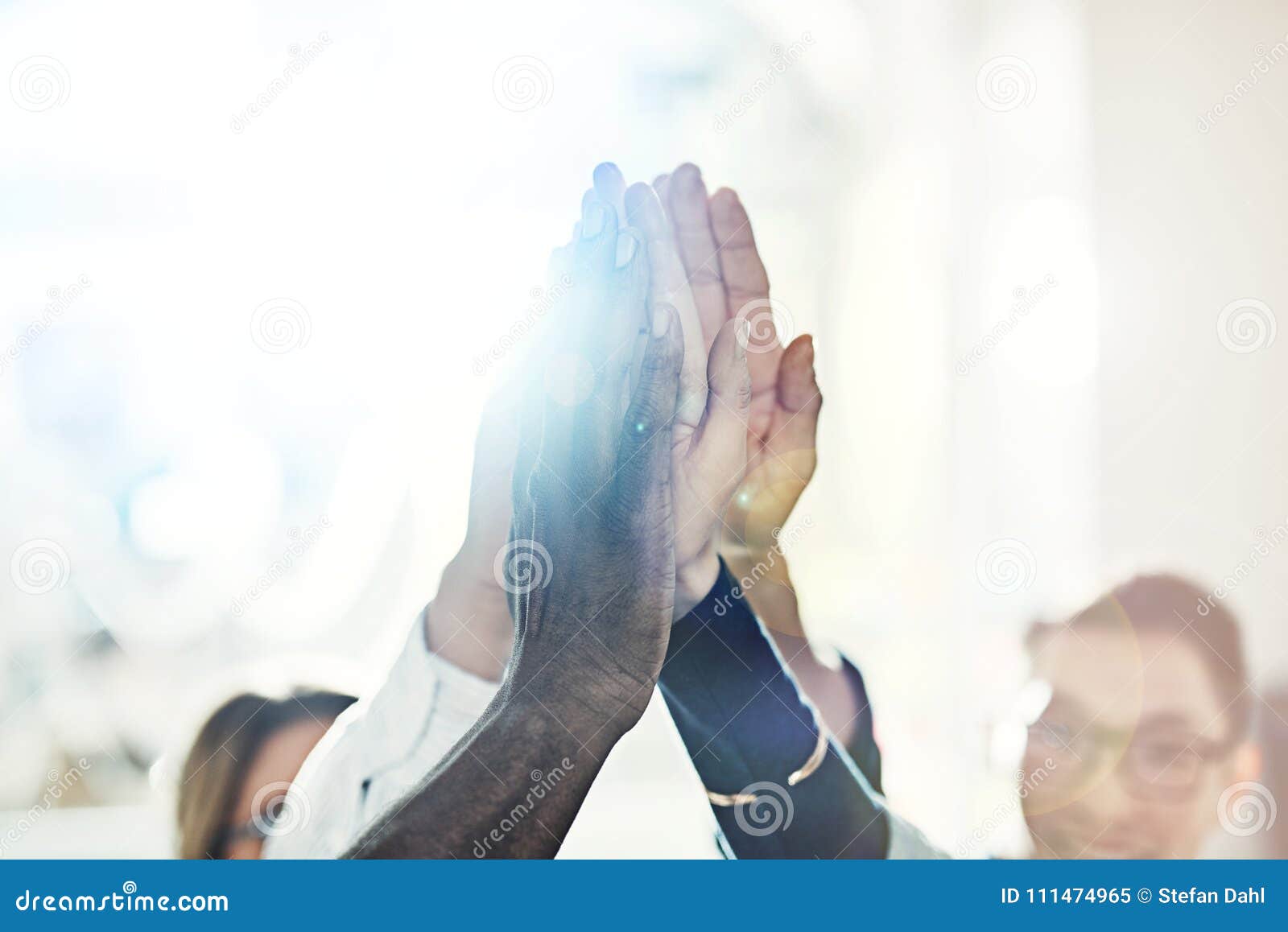 diverse businespeople standing in an office high fiving together